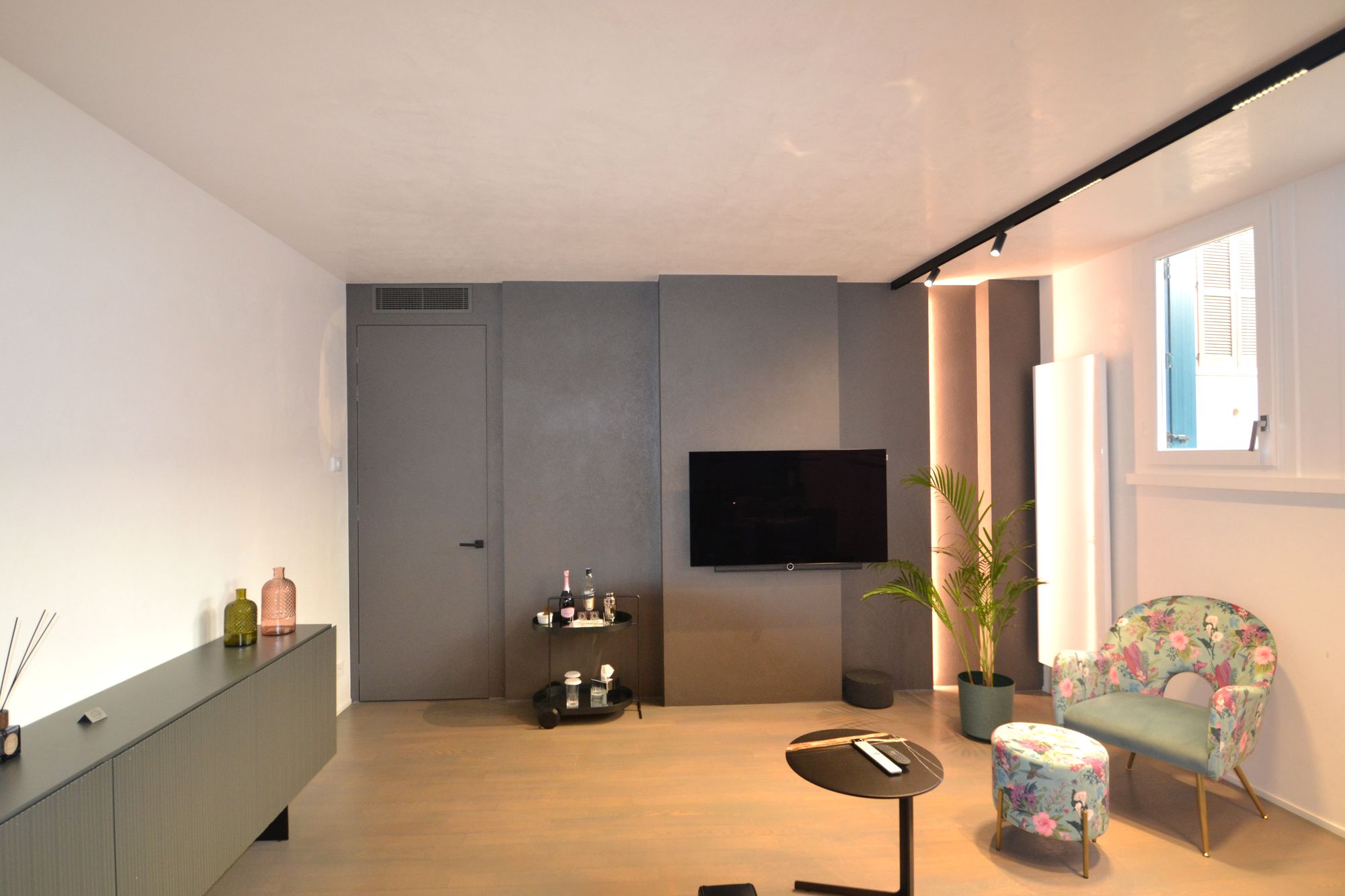 Soggiorno con parete TV e boiserie illuminata